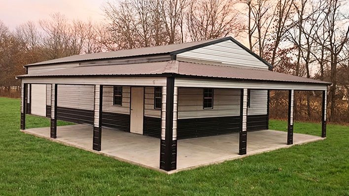 White and brown barndominium with wraparound covered porch on concrete pad